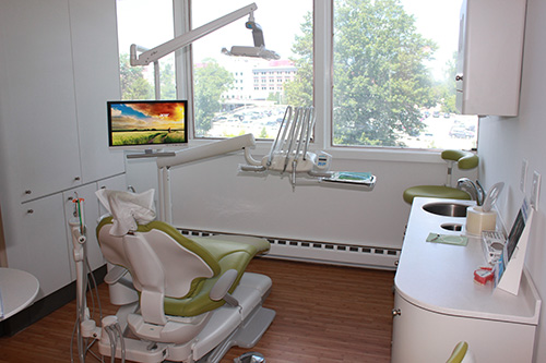 A dental office with modern equipment, including chairs, a monitor, and various dental tools.